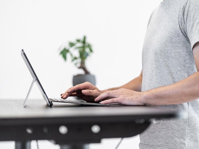 Man using a standing desk to work