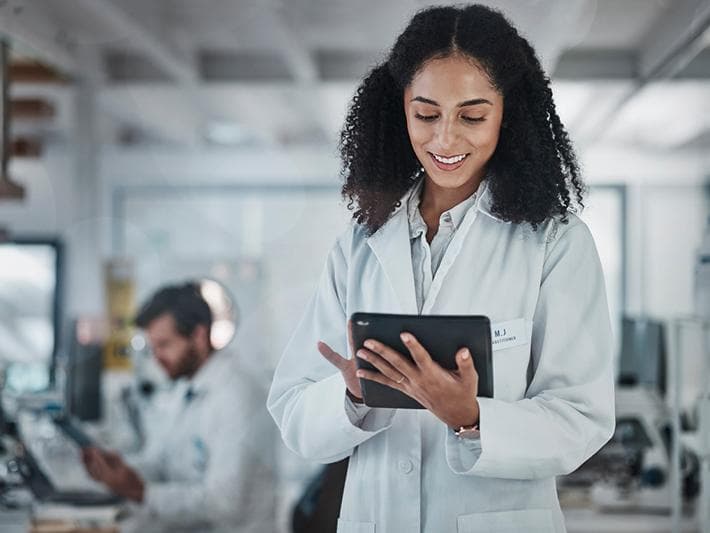 Young woman in lab coat with tablet