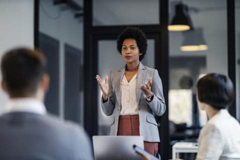 A woman gives a talk to a room of people