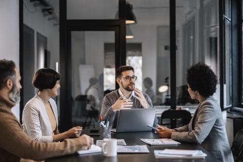 A group of people work around an office table