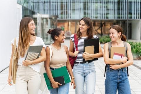 Students standing and chatting outside of a campus building