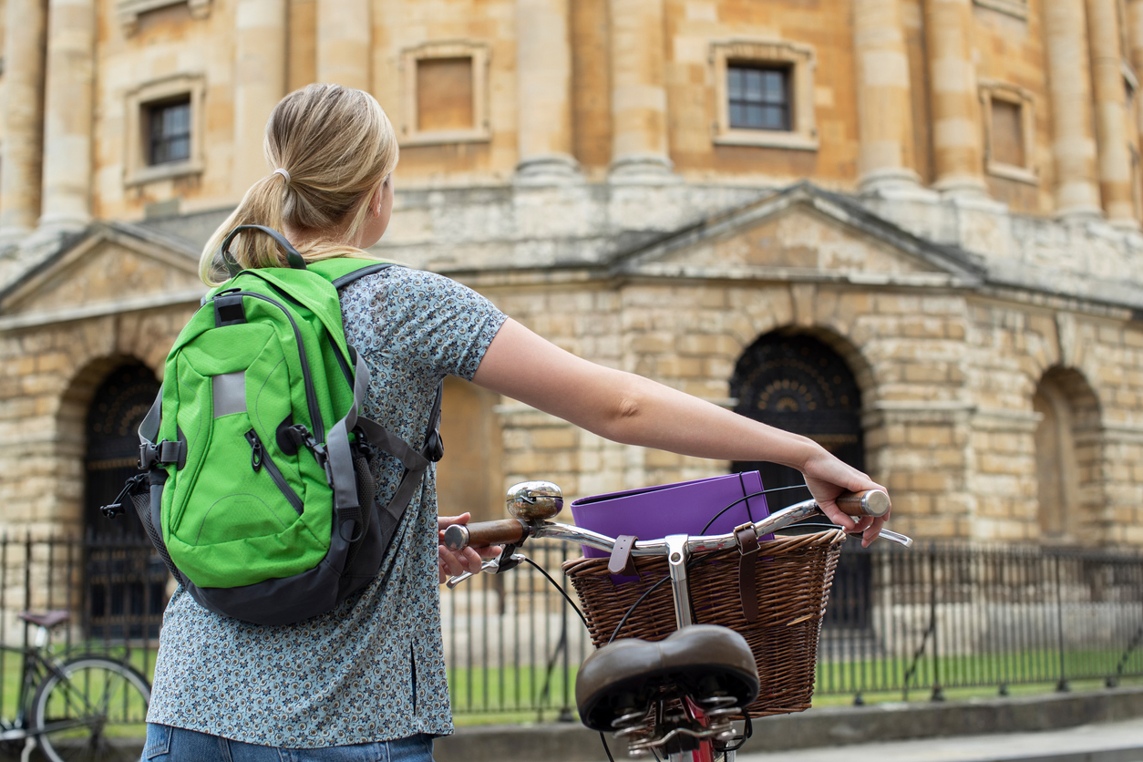 Female student with bicycle, outside Radcliffe Camera, Oxford