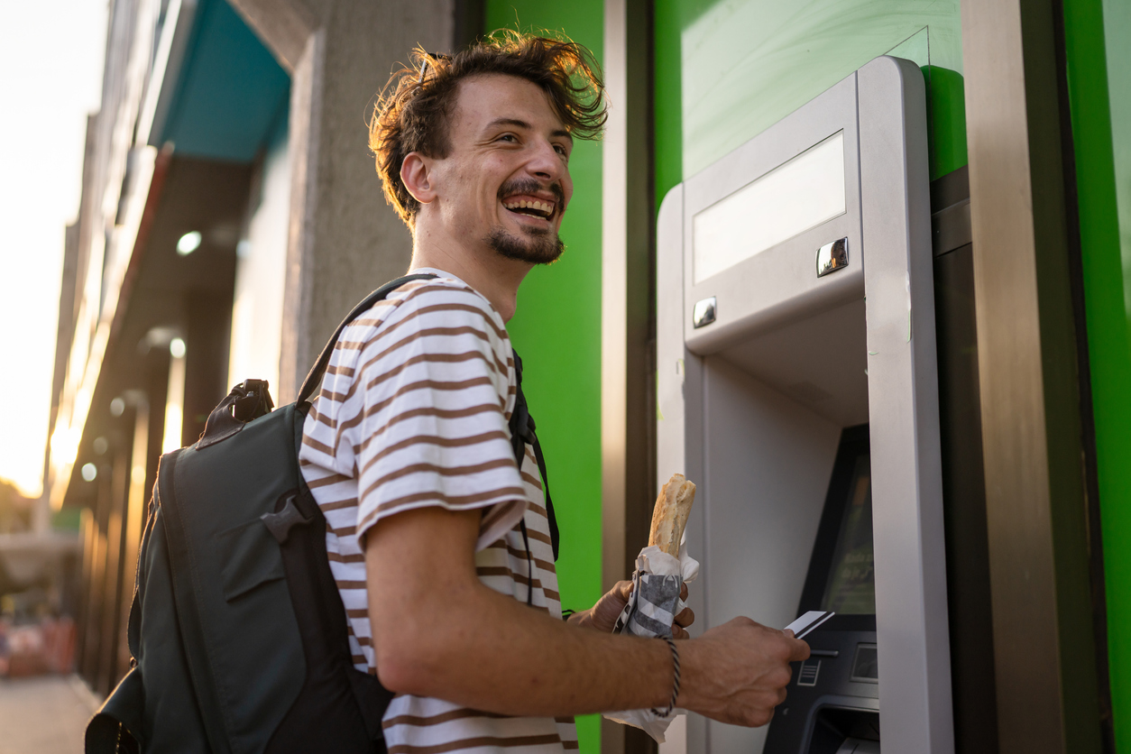 Student, standing with sandwich at cashpoint