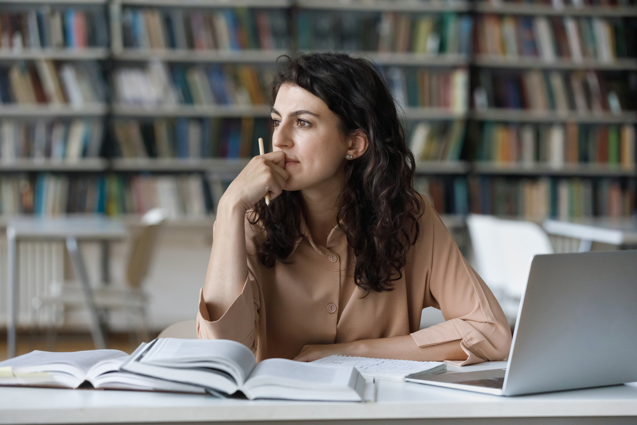 Student sitting at laptop, looking pensive