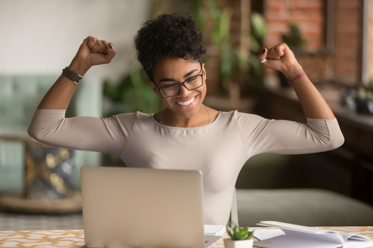 Student at laptop, cheering 