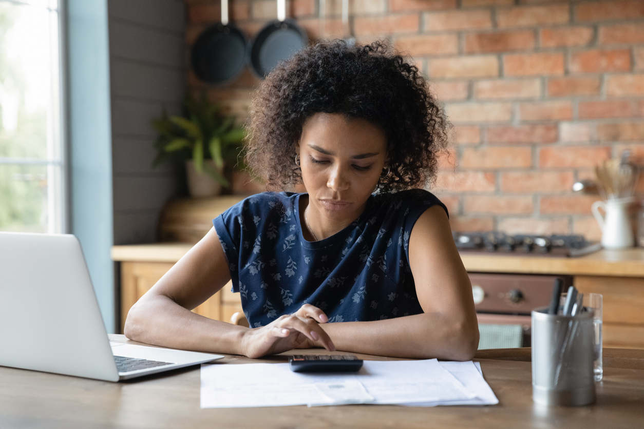 Student, sitting at desk with laptop and calculator