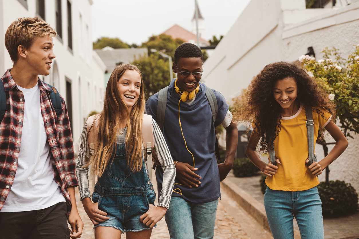 Four students, walking and laughing together