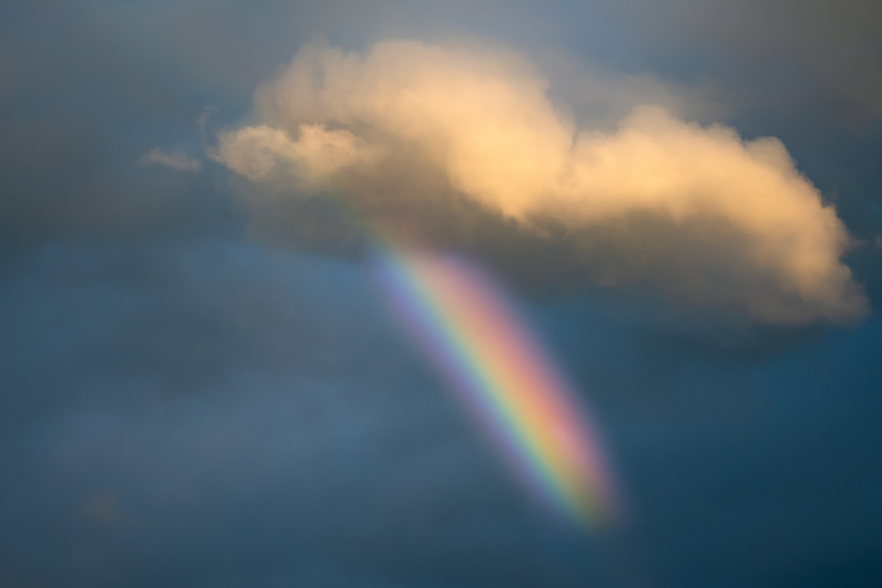 Rainbow peeking through storm clouds