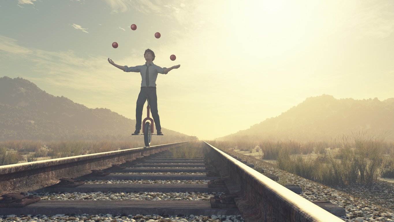 Juggler on a unicycle, balancing on railway tracks