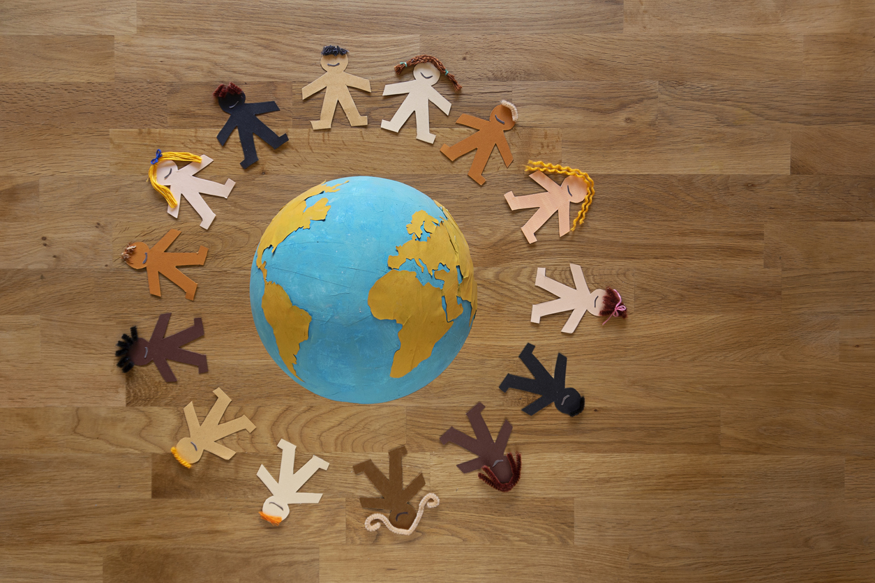 Multiethnic paper dolls, encircling the Earth