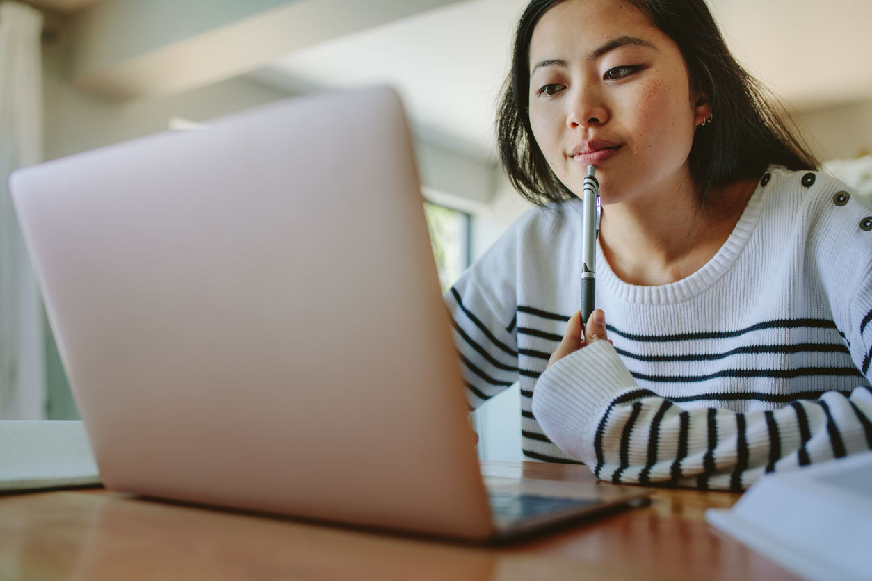 Student, looking pensively at her laptop 