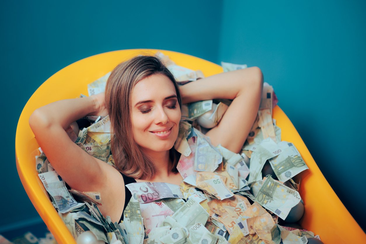 Woman lying in bath filled with cash