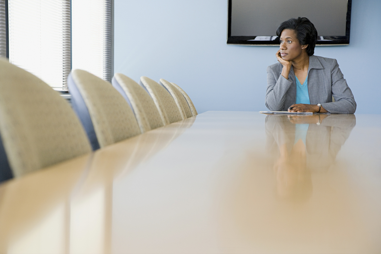 Woman sitting alone at boardroom table