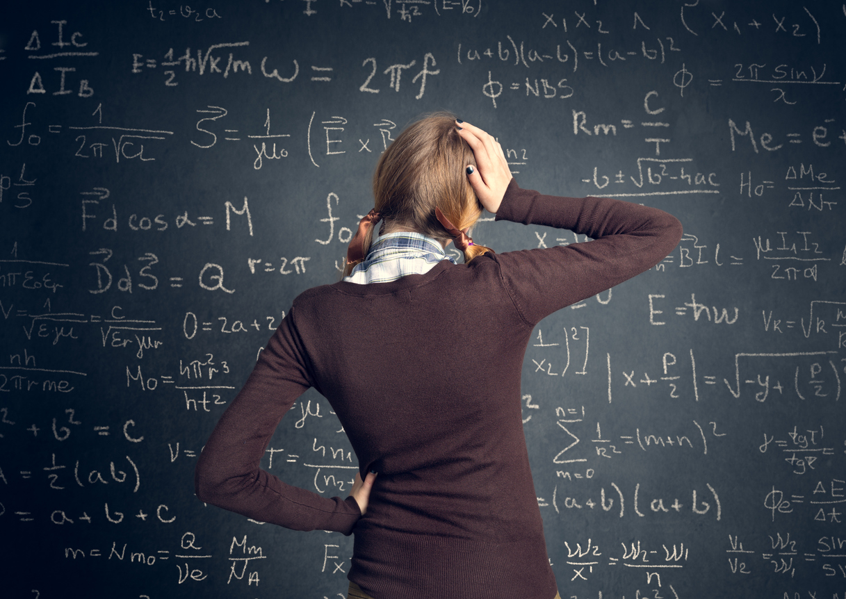 Student looking at complicated maths problem on blackboard