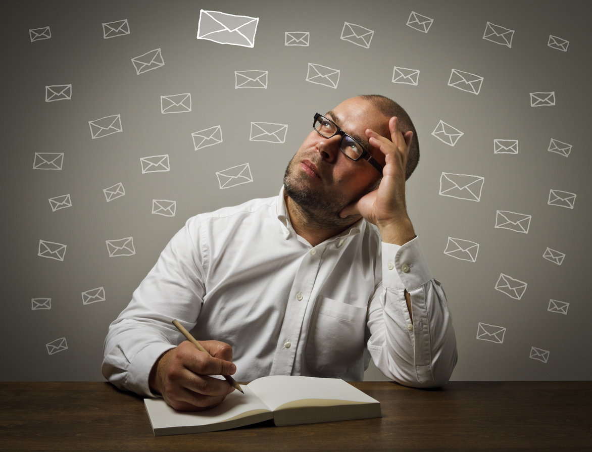 Man, writing letter, surrounded by images of envelopes