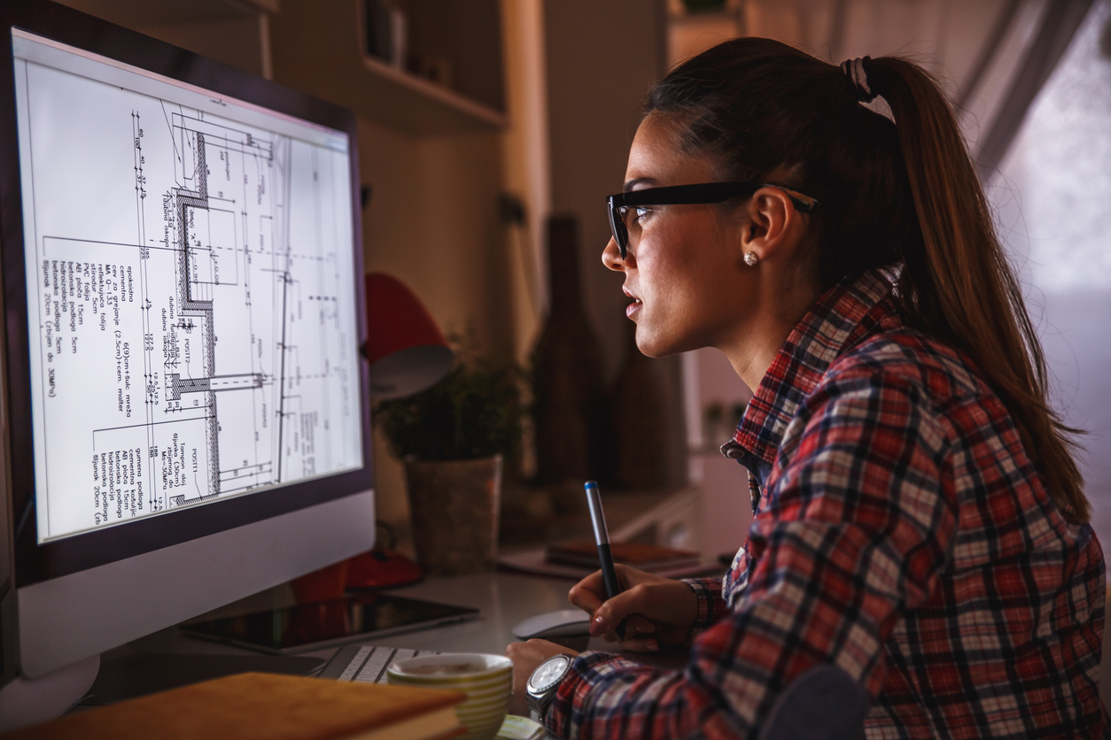 Architect, studying a house plan on her computer