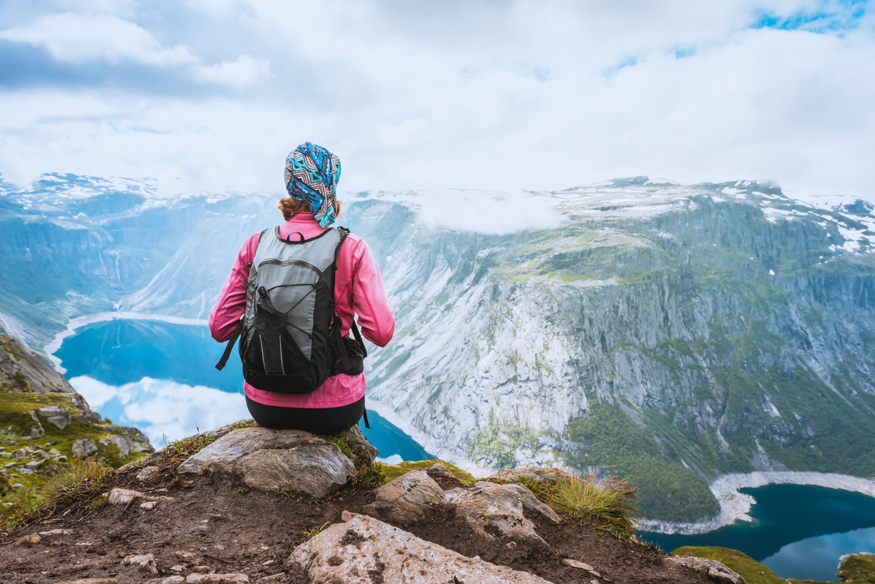 Student sits on edge of Norwegian fjord