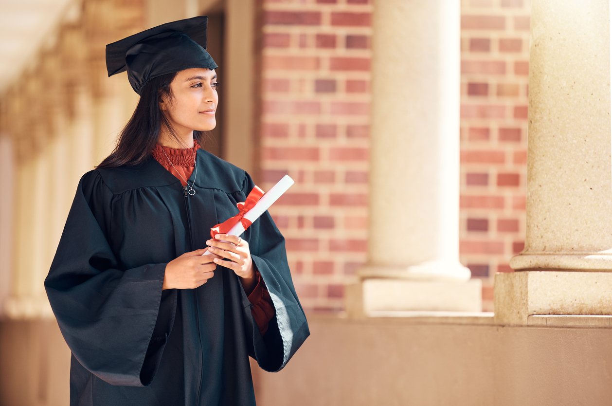 Graduate in cap and gown, looking pensive