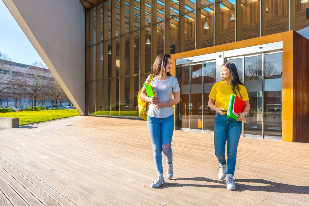 Two students, walking into university building in Spain