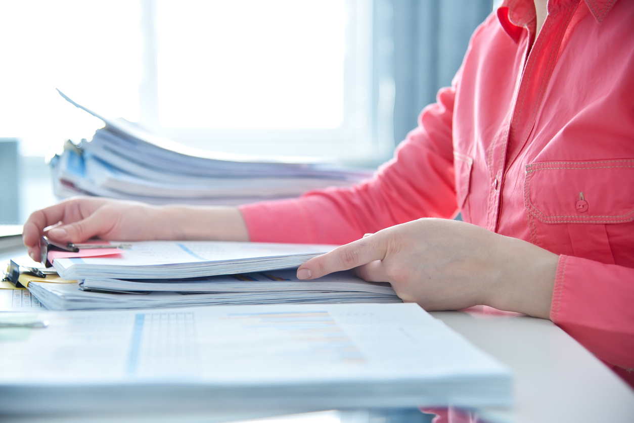 Woman looking through piles of papers