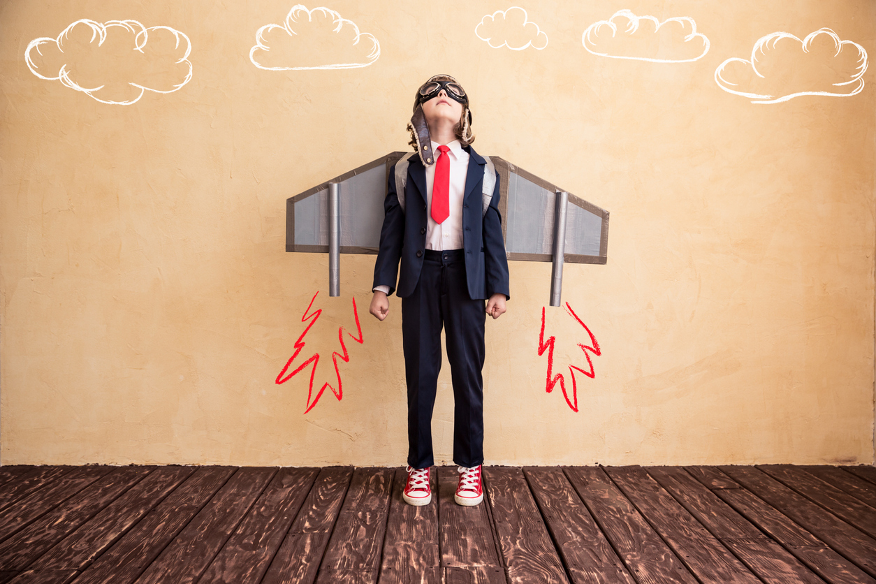 Child in suit, with drawn-on rocket-powered wings