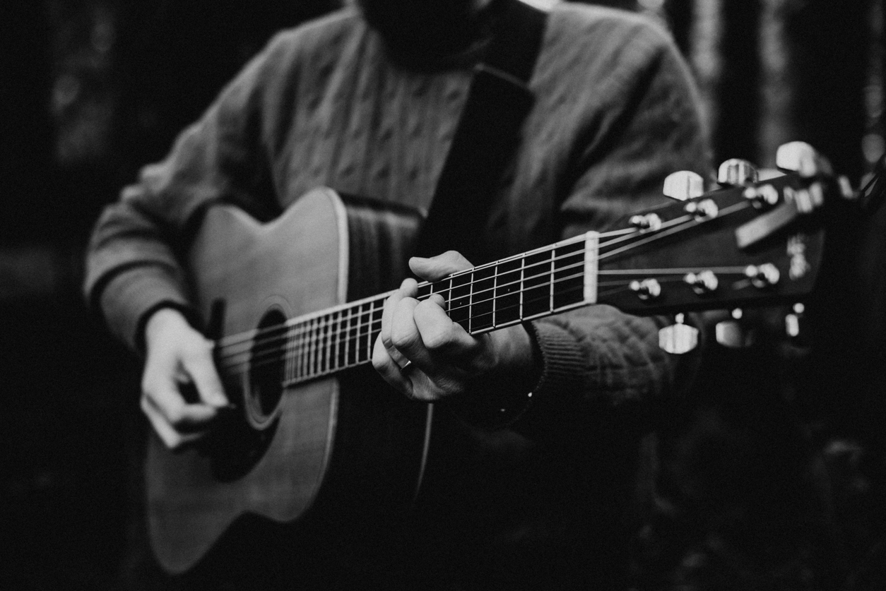 Black and white photograph of folk singer, playing guitar