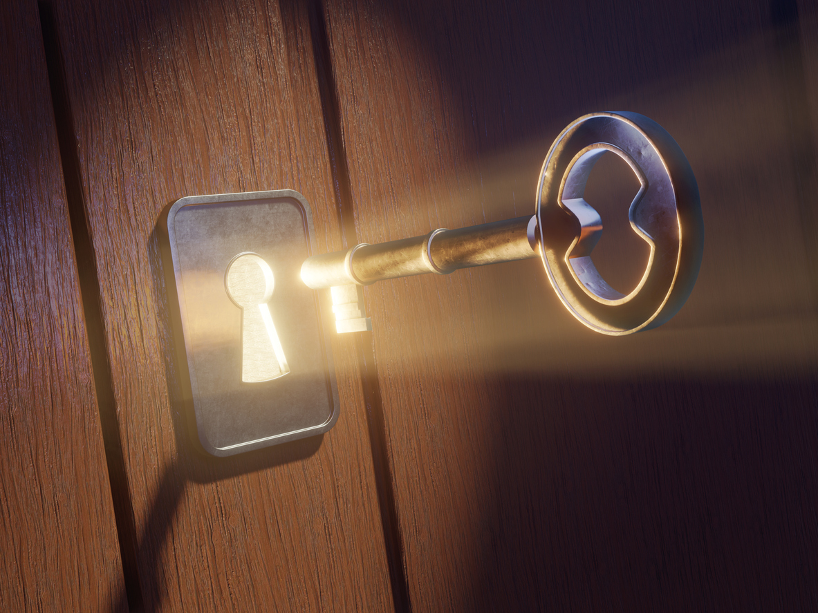 Light shining through keyhole, as key is inserted