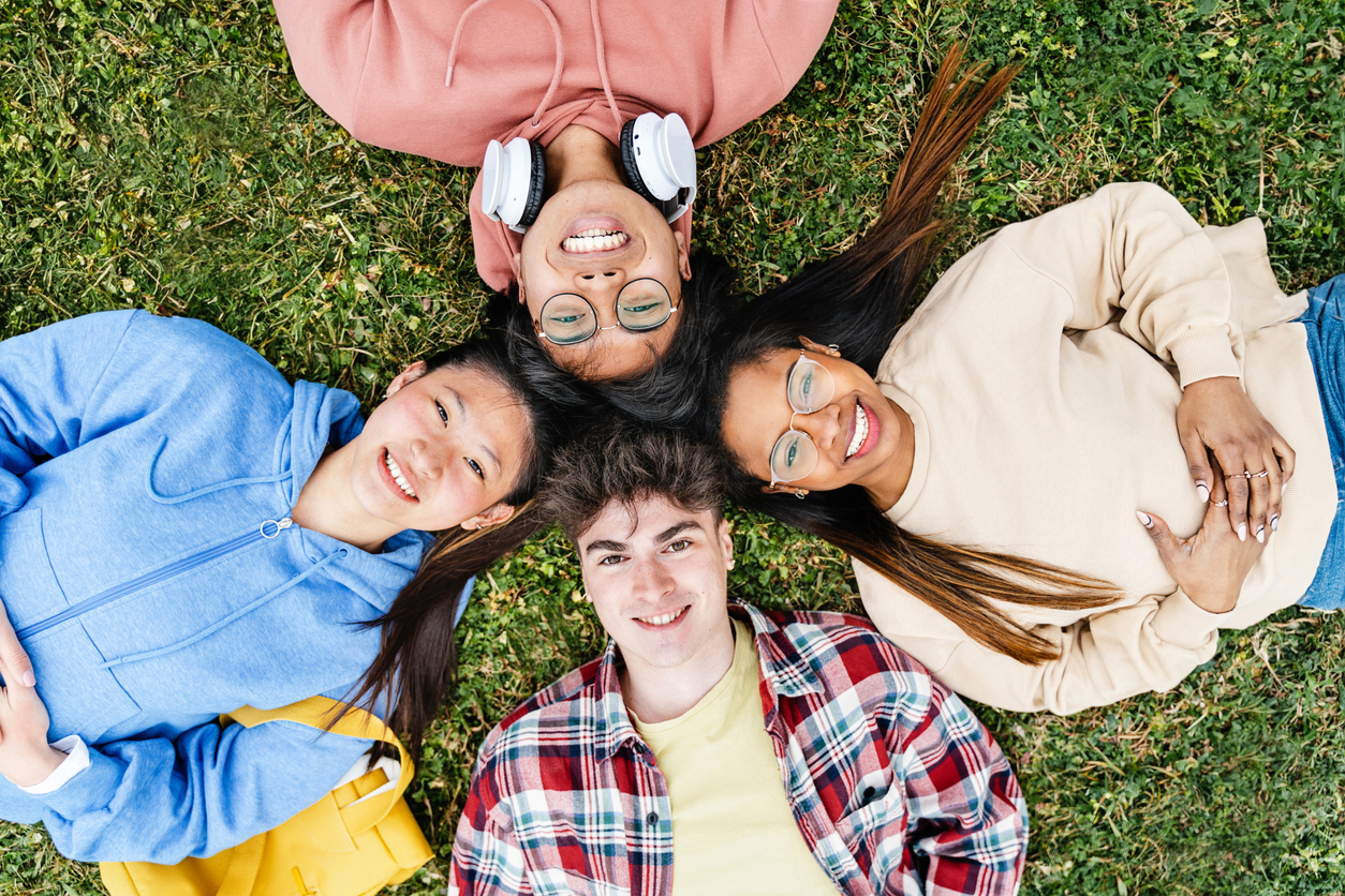 Four teenagers, lying on the grass