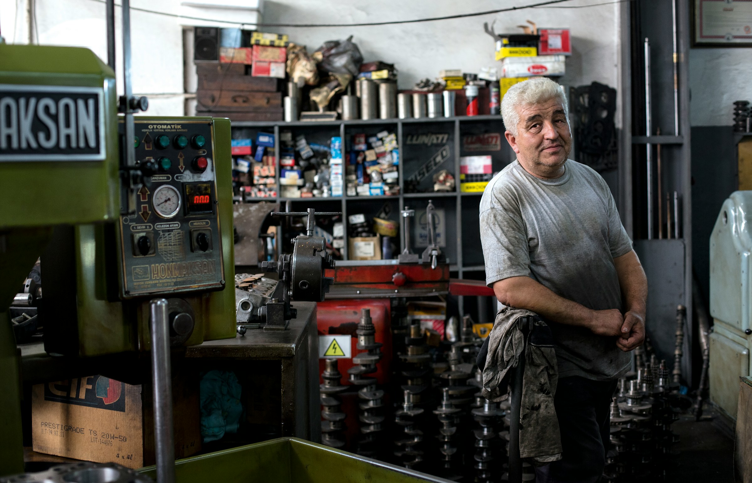 An industrial / factory worker stands by their machine