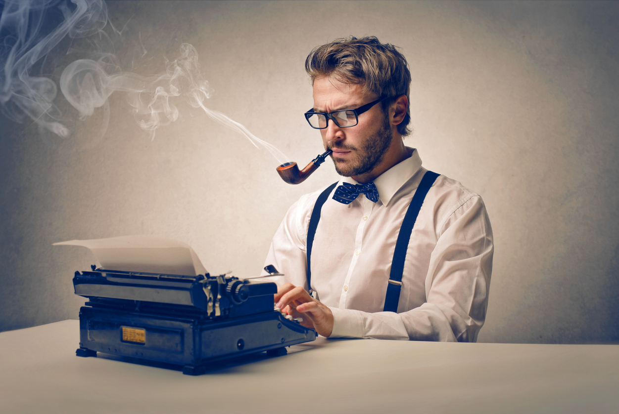 Author smoking pipe and sitting at typewriter