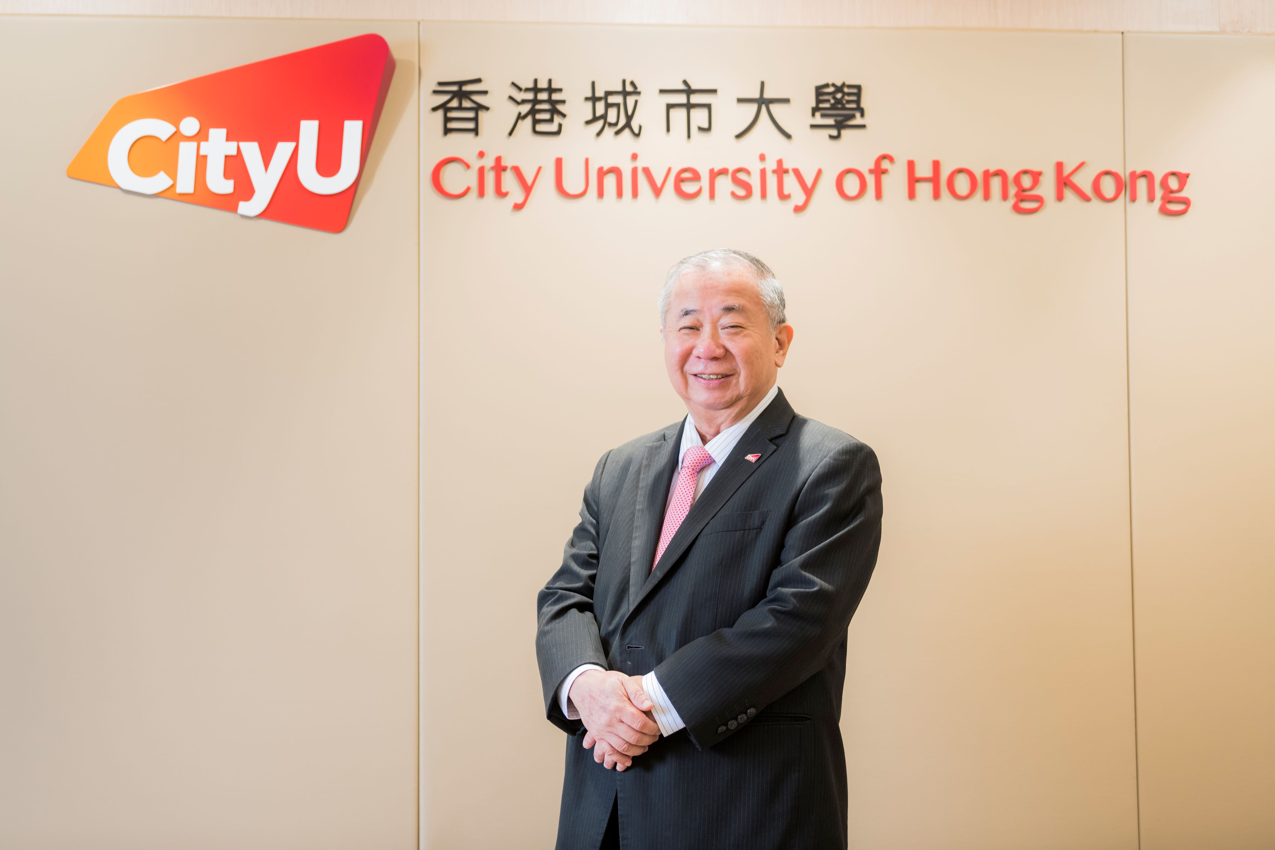 Freddy Boey, president of City University of Hong Kong, stands in front of the university's logo