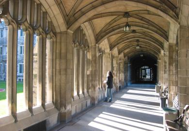 Student standing in Oxbridge college cloister