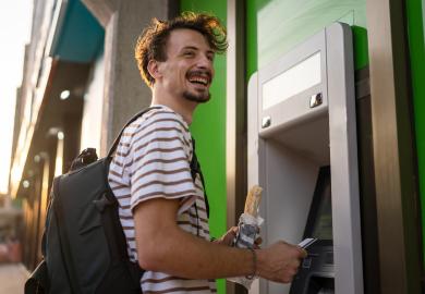 Student, standing with sandwich at cashpoint