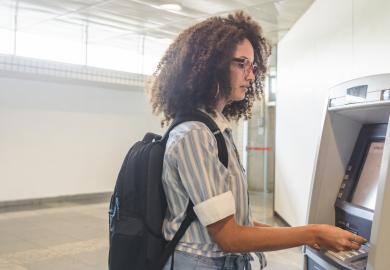 A student withdraws money from a cashpoint