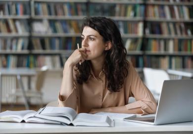 Student sitting at laptop, looking pensive