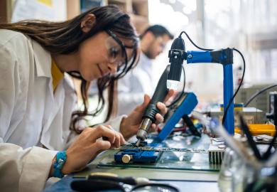 Female vocational student working on circuit board