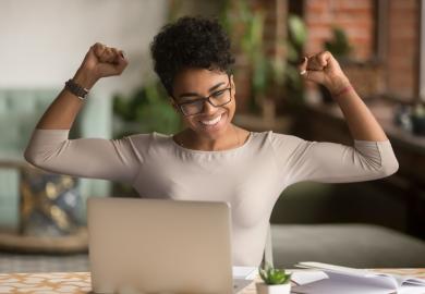 Student at laptop, cheering 