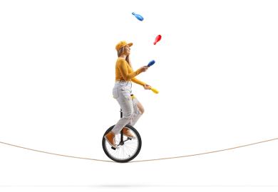 Unicyclist juggling on a high wire