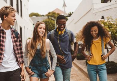 Four students, walking and laughing together