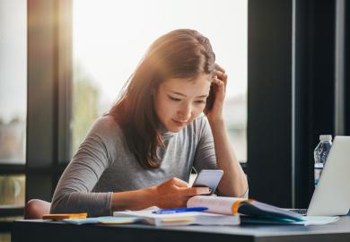 Student checks phone while studying