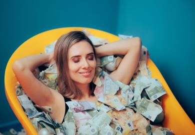 Woman lying in bath filled with cash