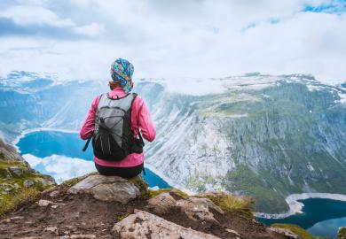 Student sits on edge of Norwegian fjord