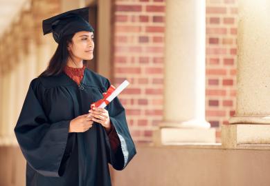 Graduate in cap and gown, looking pensive