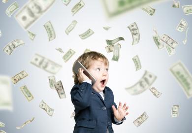 Toddler in suit speaks on phone, while dollar bills fly through the air