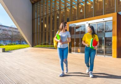 Two students, walking into university building in Spain