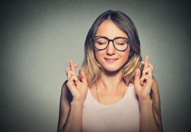 Student with her fingers crossed on both hands