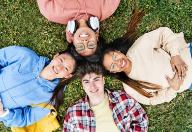 Four teenagers, lying on the grass