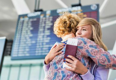 Mother and daughter embracing in airport