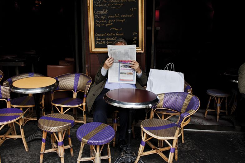 Man reading newspaper in cafe