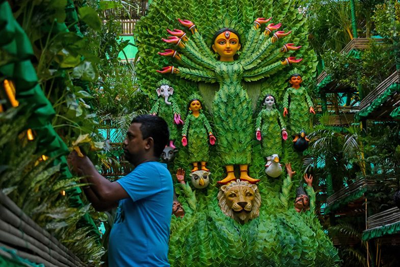 People tend to various plants surrounding an idol of Durga, which is made to promote sustainability through planting trees, Kolkata, India. To illustrate a key focus of financial sustainability for branch campuses.